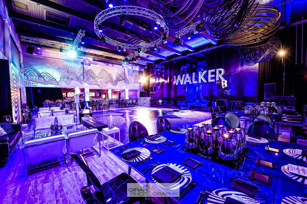 A large room with tables and chairs and a sign that says walker on the ceiling.