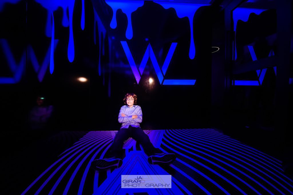 A person is kneeling down in front of a wall that says white