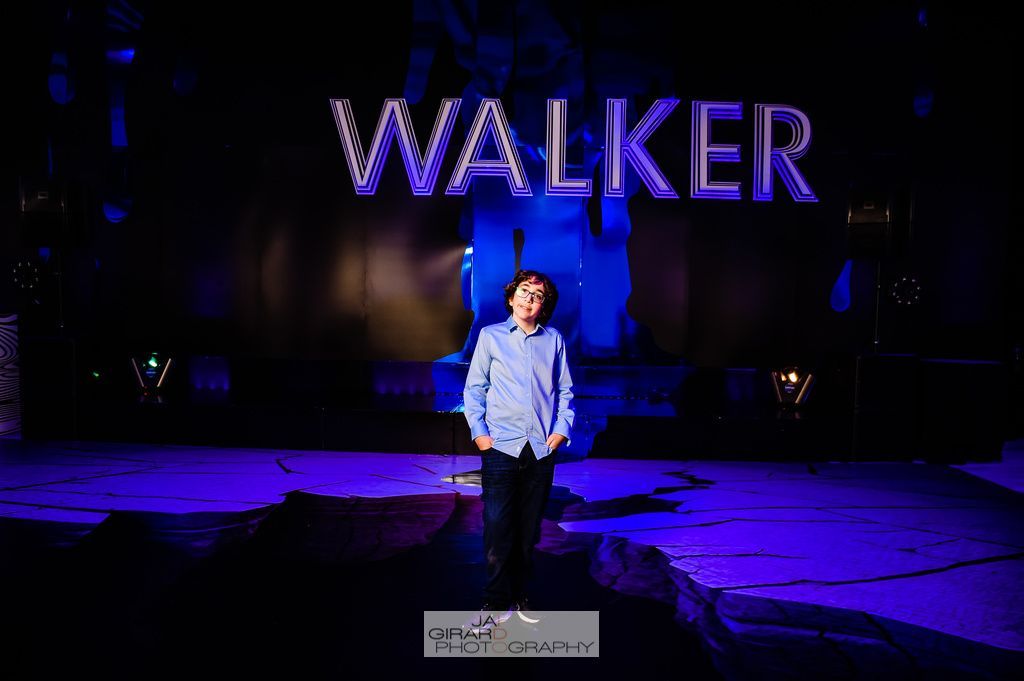 A man is standing on a stage in front of a sign that says walker.