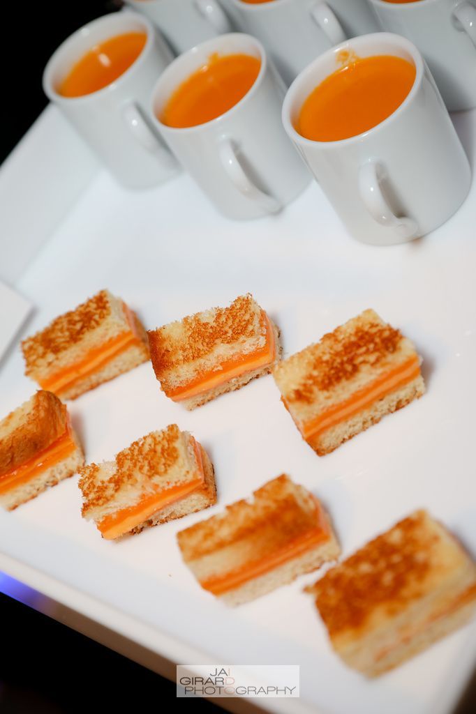 A white plate topped with sandwiches and cups of soup