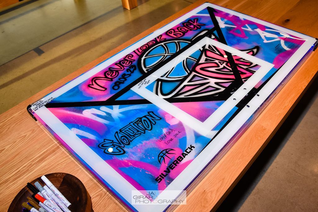 A painting of a basketball hoop is on a wooden table