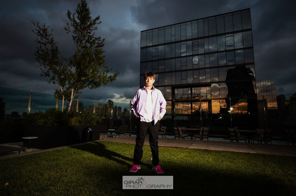A young boy is standing in front of a large building.
