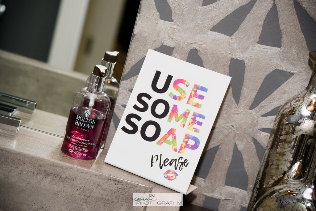 A bathroom counter with a soap dispenser and a sign that says `` use some soap please ''.
