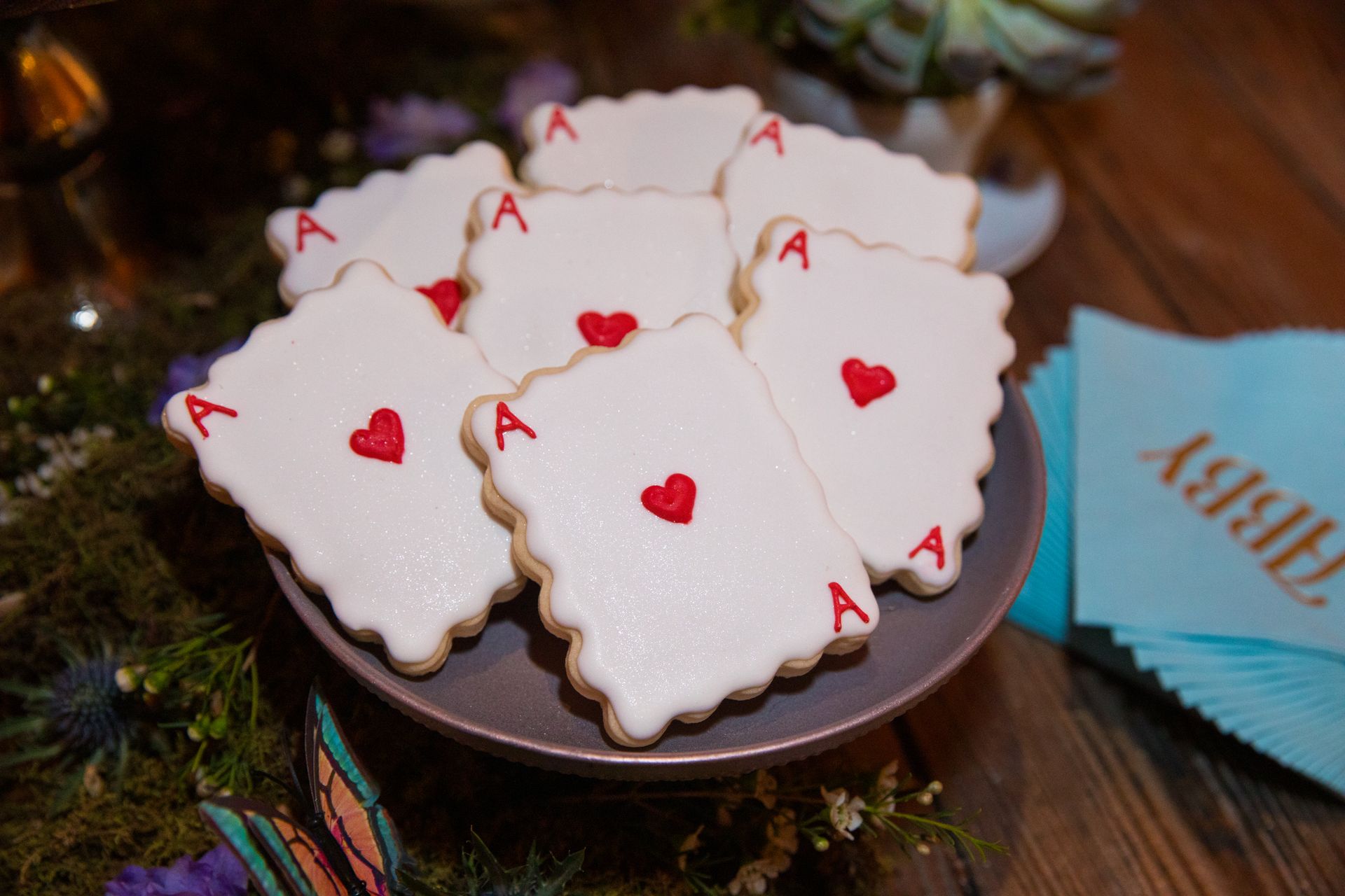 A plate of cookies with playing cards on them on a table.