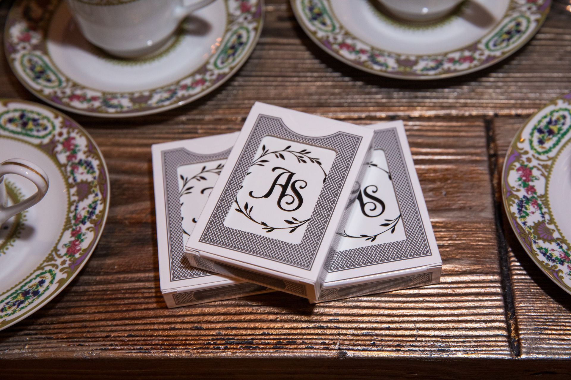 Three playing cards with the letter s on them are sitting on a wooden table.