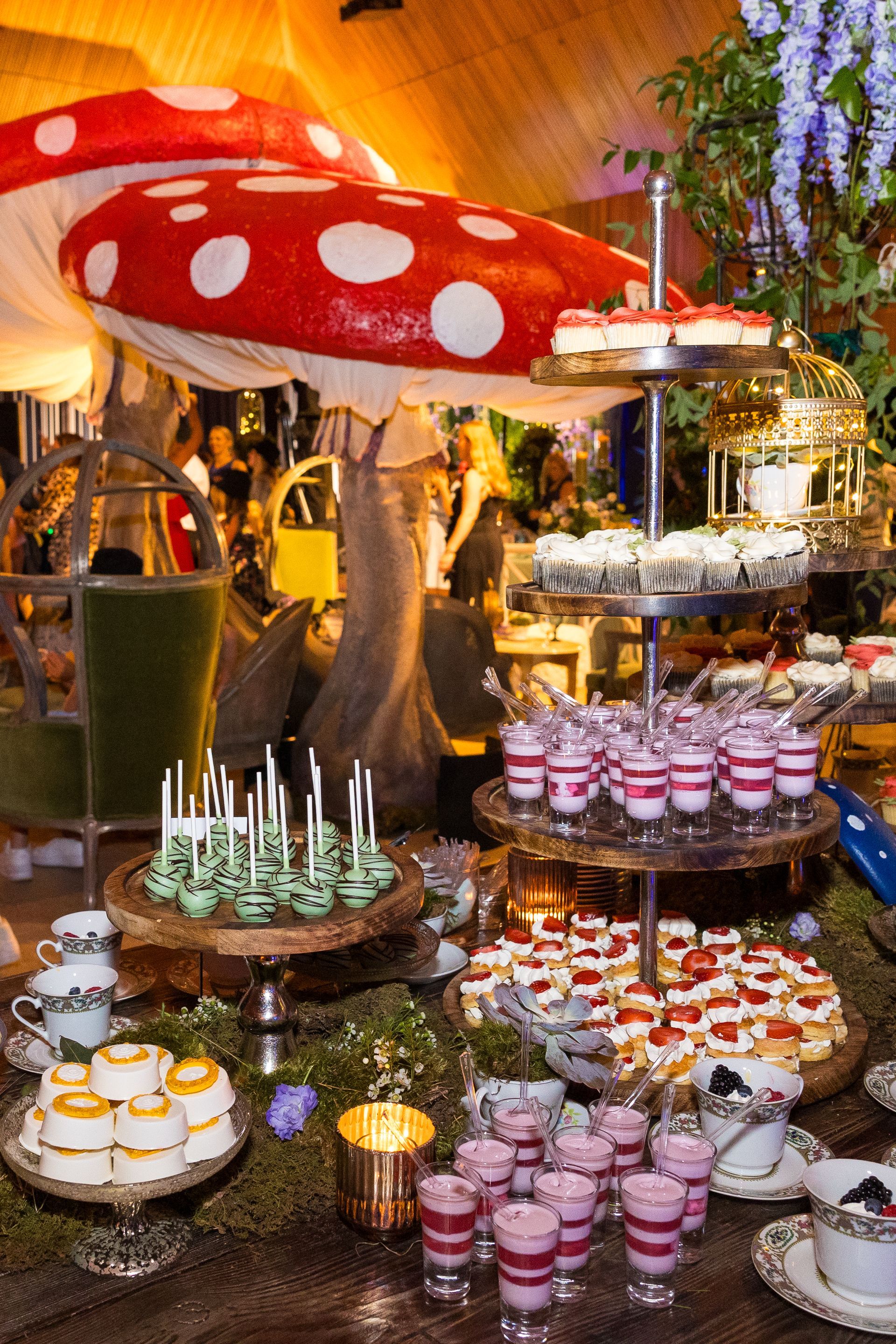 A table topped with lots of desserts and a large mushroom.