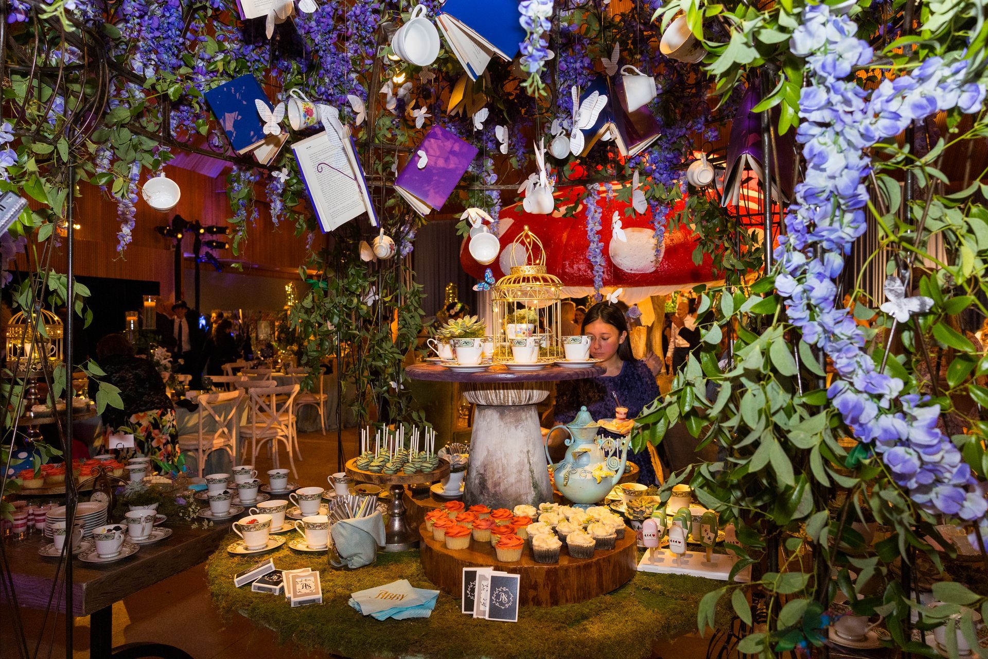 A woman is standing in front of a table with a lot of food on it.