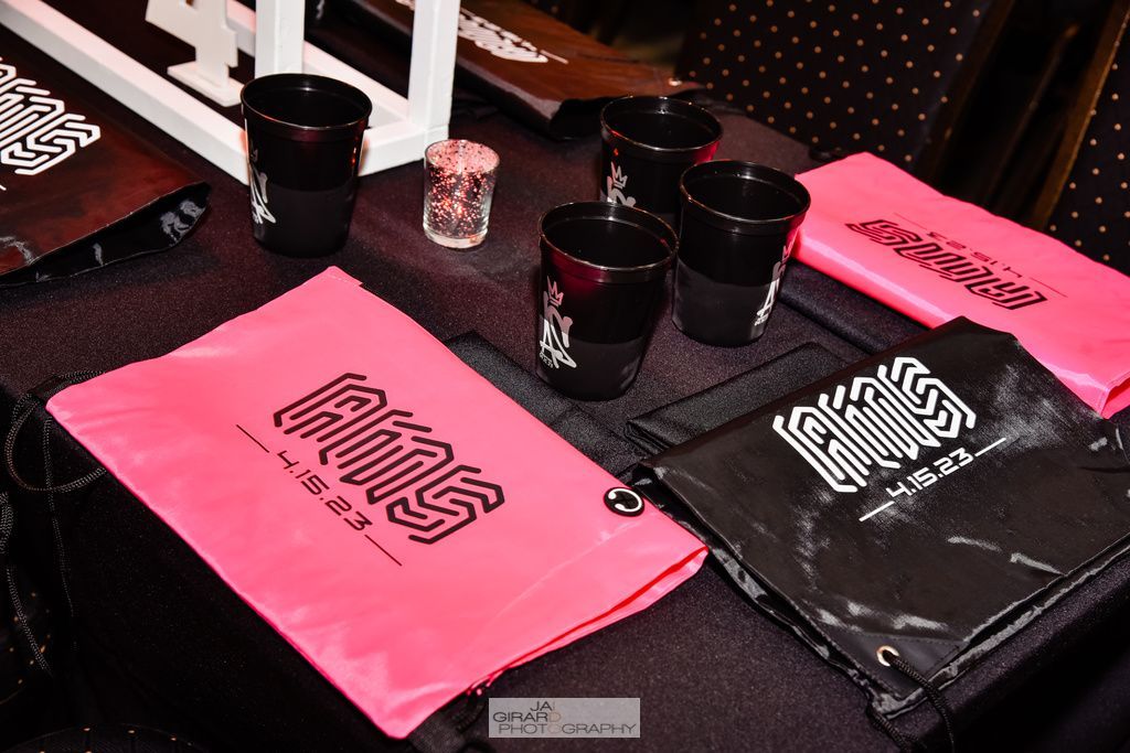 A table with a lot of pink and black items on it