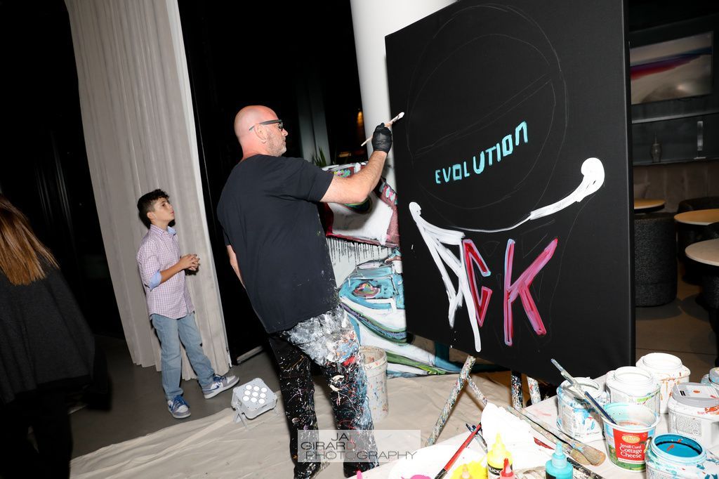 A man is painting a picture with the word evolution on it