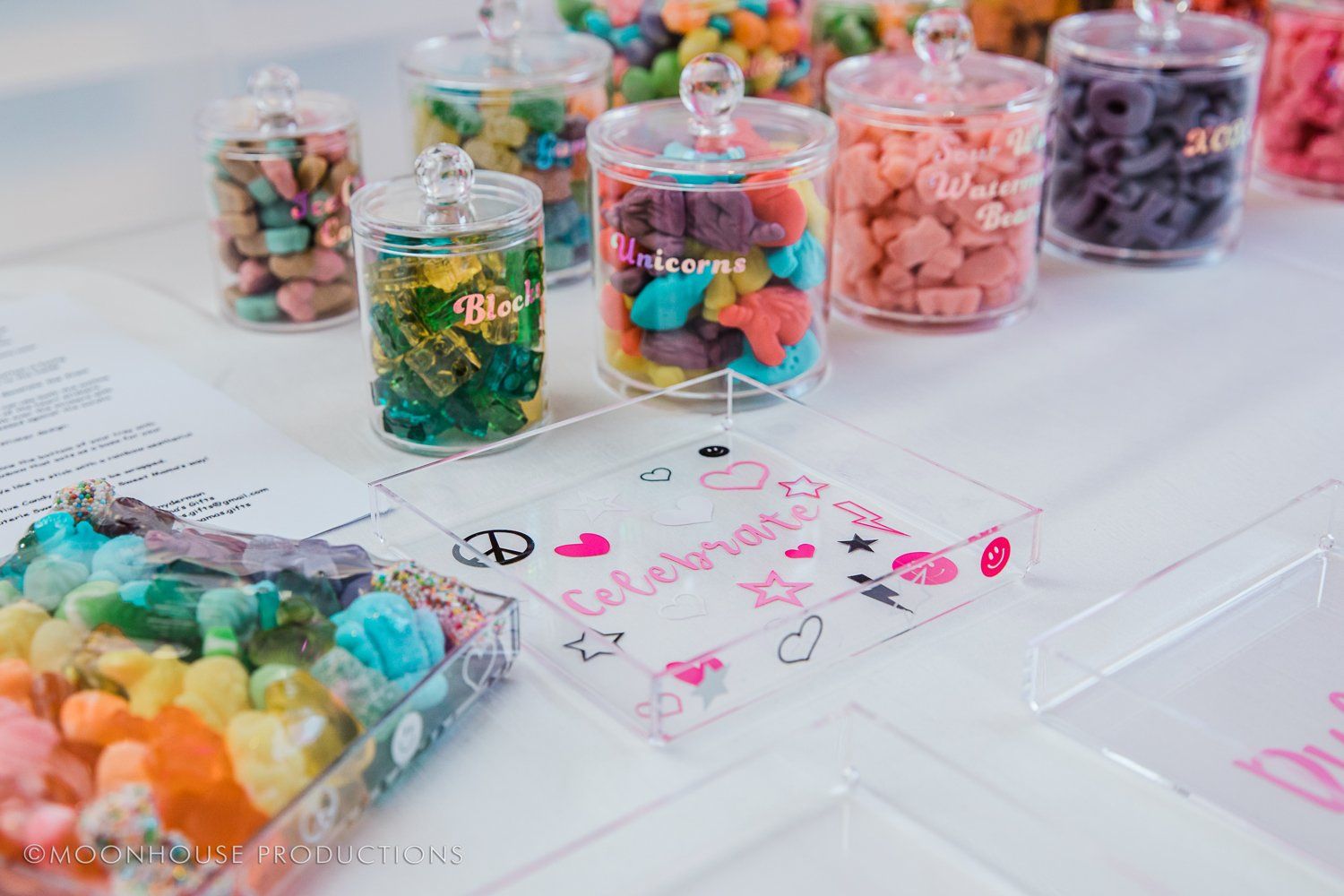 A table topped with jars filled with different types of candy.