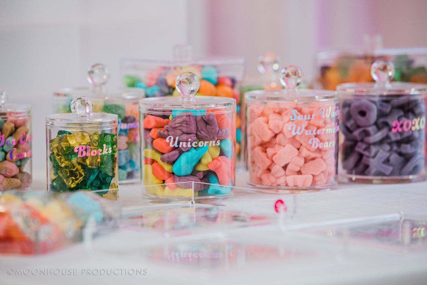 A table topped with jars filled with different types of candy.