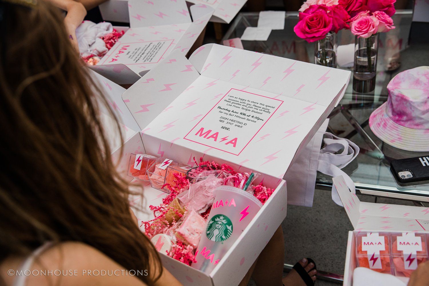 A woman is looking at a box with a starbucks cup in it.