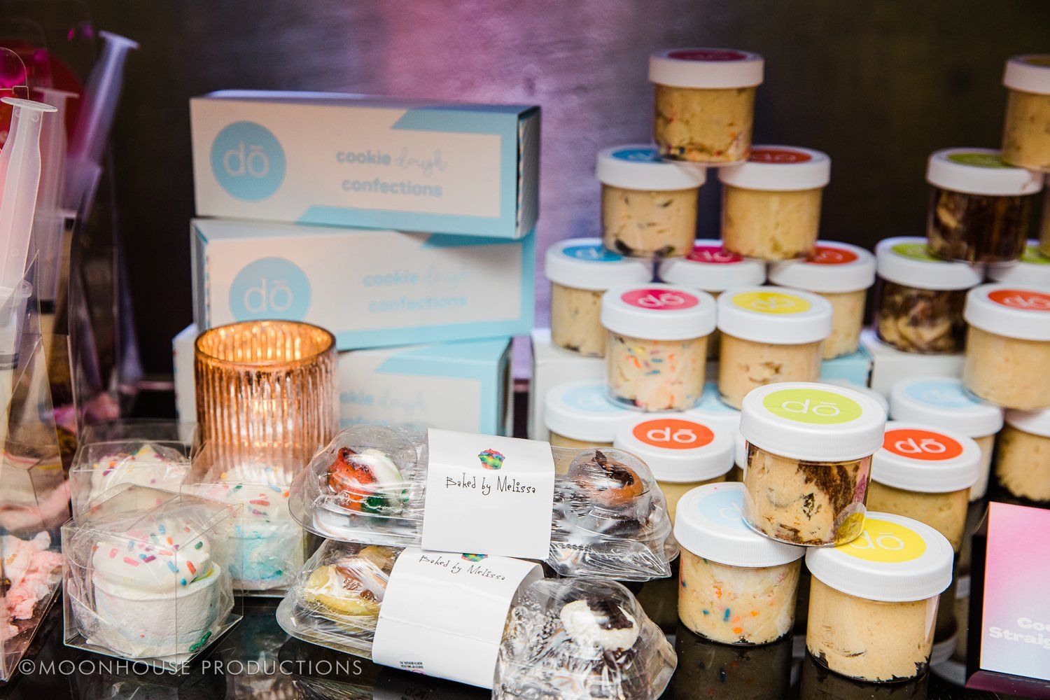 A bunch of jars of food are stacked on top of each other on a table.