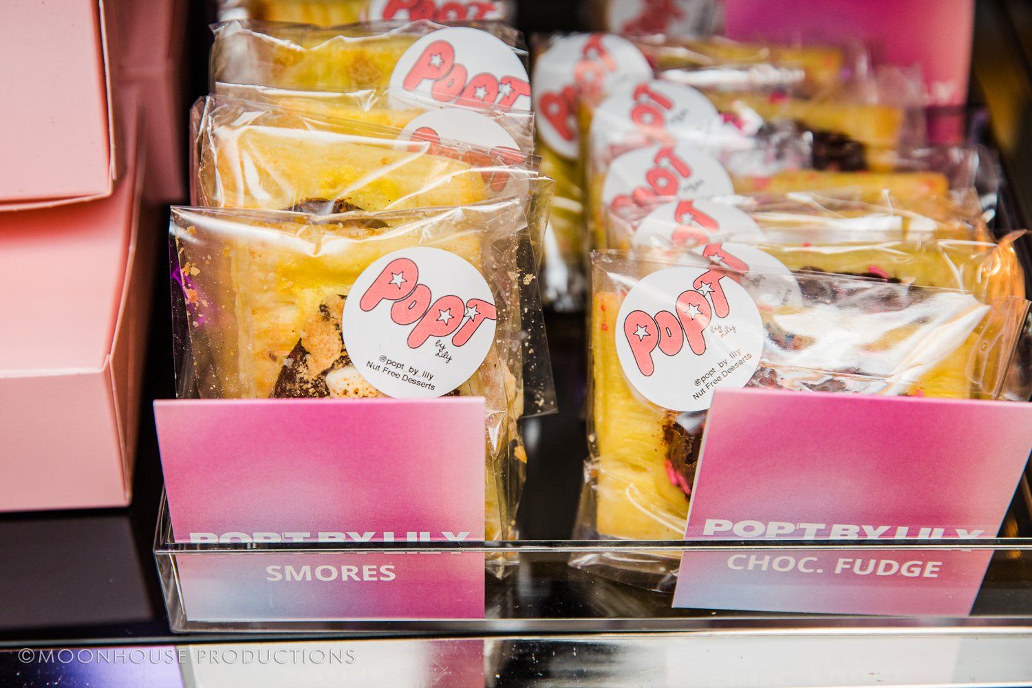 A display case filled with a variety of desserts including s'mores and chocolate fudge.