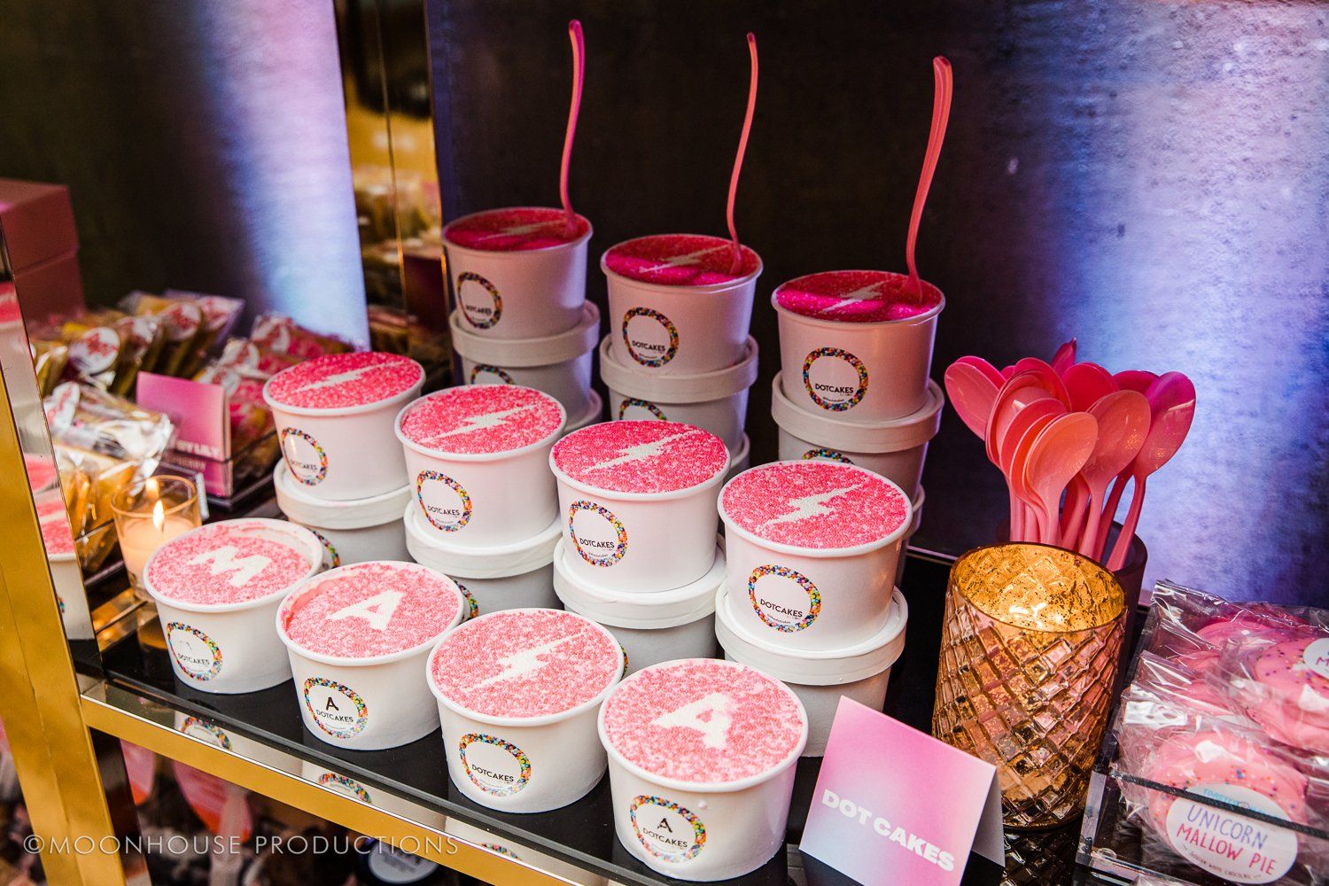 A table topped with ice cream cups and pink spoons.
