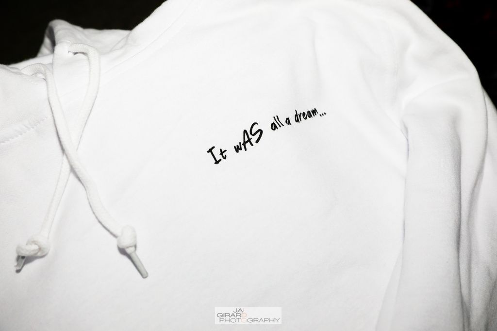 A white hoodie with the words it was written on it
