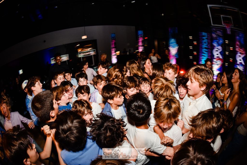 A large group of children are dancing at a party.