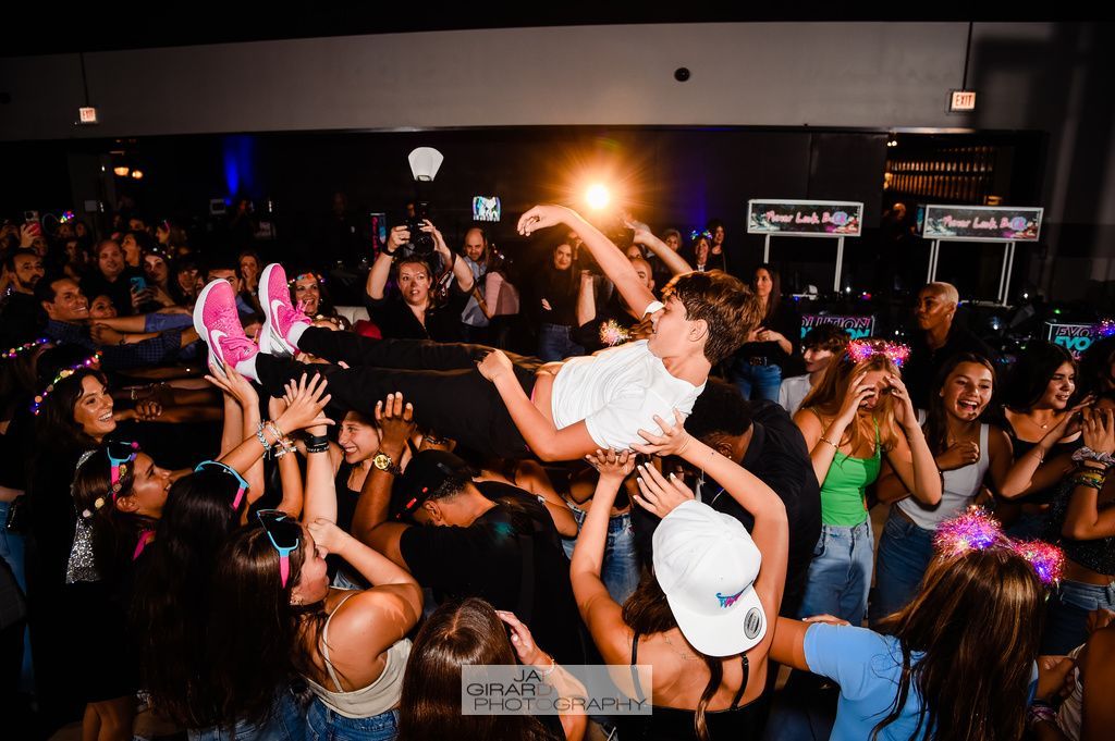 A woman is being lifted in the air by a crowd of people at a party.
