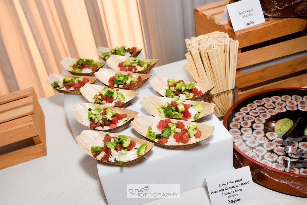 A table topped with plates of food and a bowl of sushi.