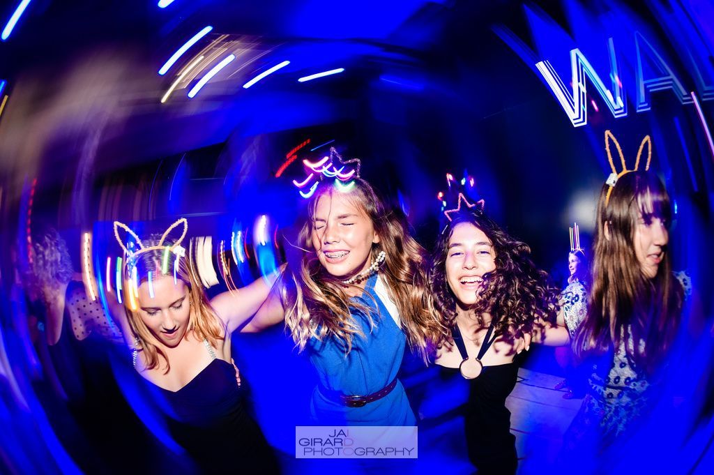 A group of young women are dancing in a dark room.