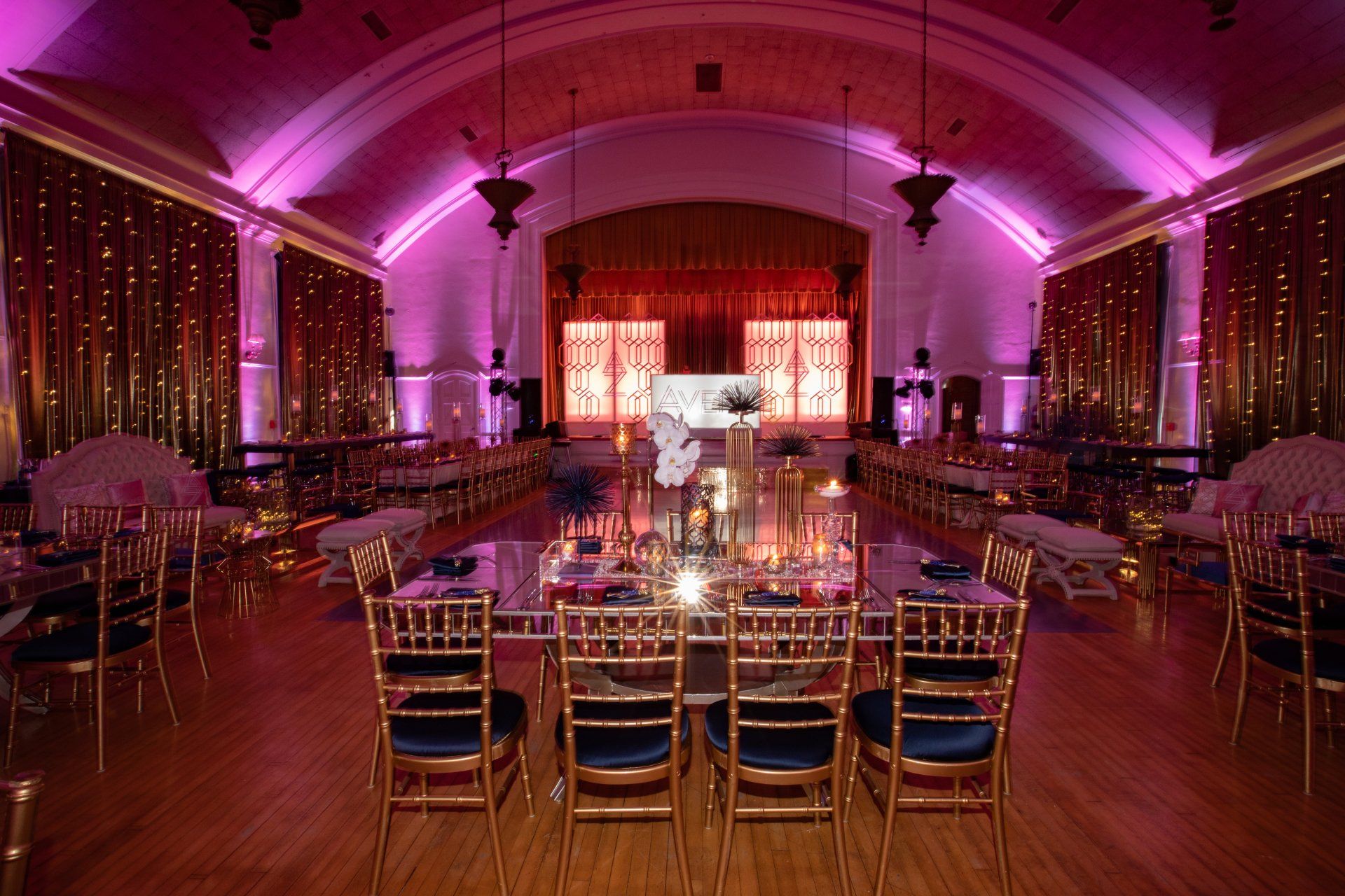 A large room with tables and chairs set up for a party.