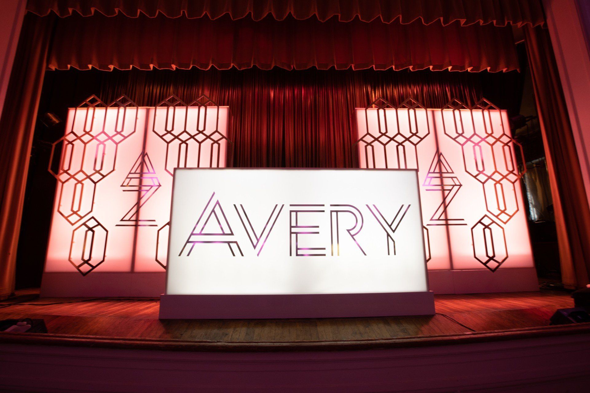 A white sign with the word avery on it is on a stage.