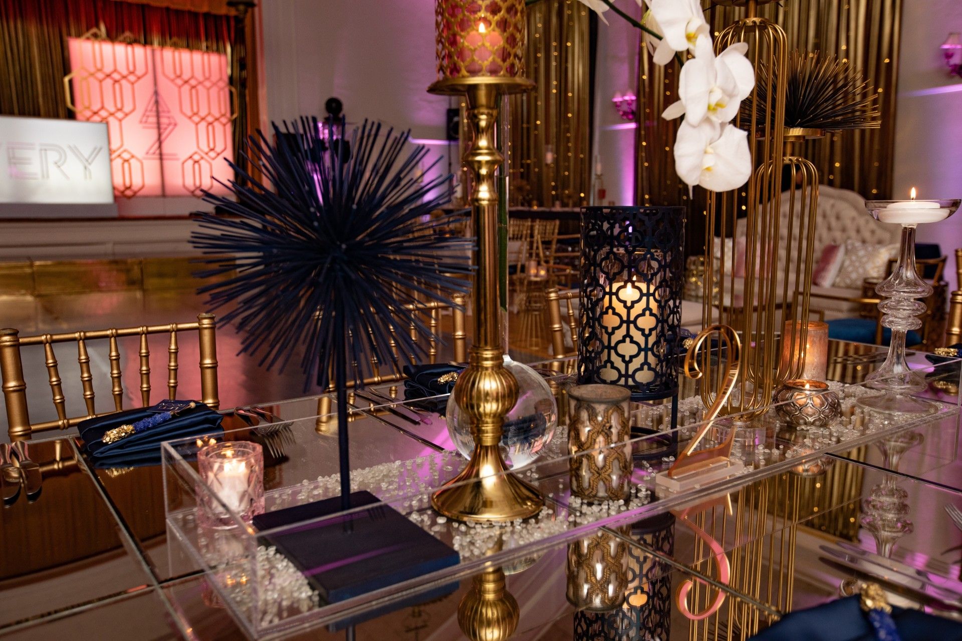 A table with a lot of candles and flowers on it.