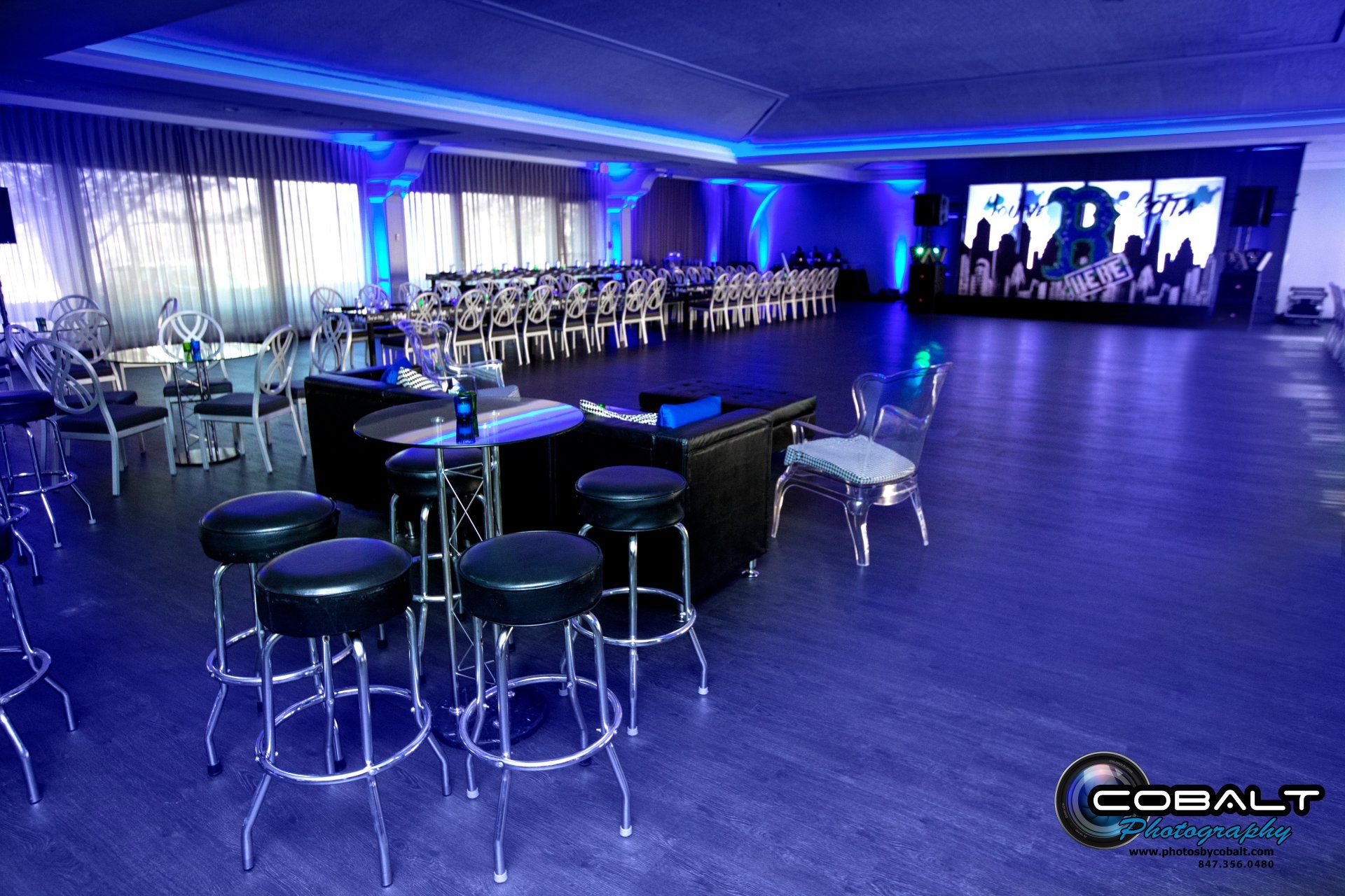 A large room with blue lights and tables and chairs