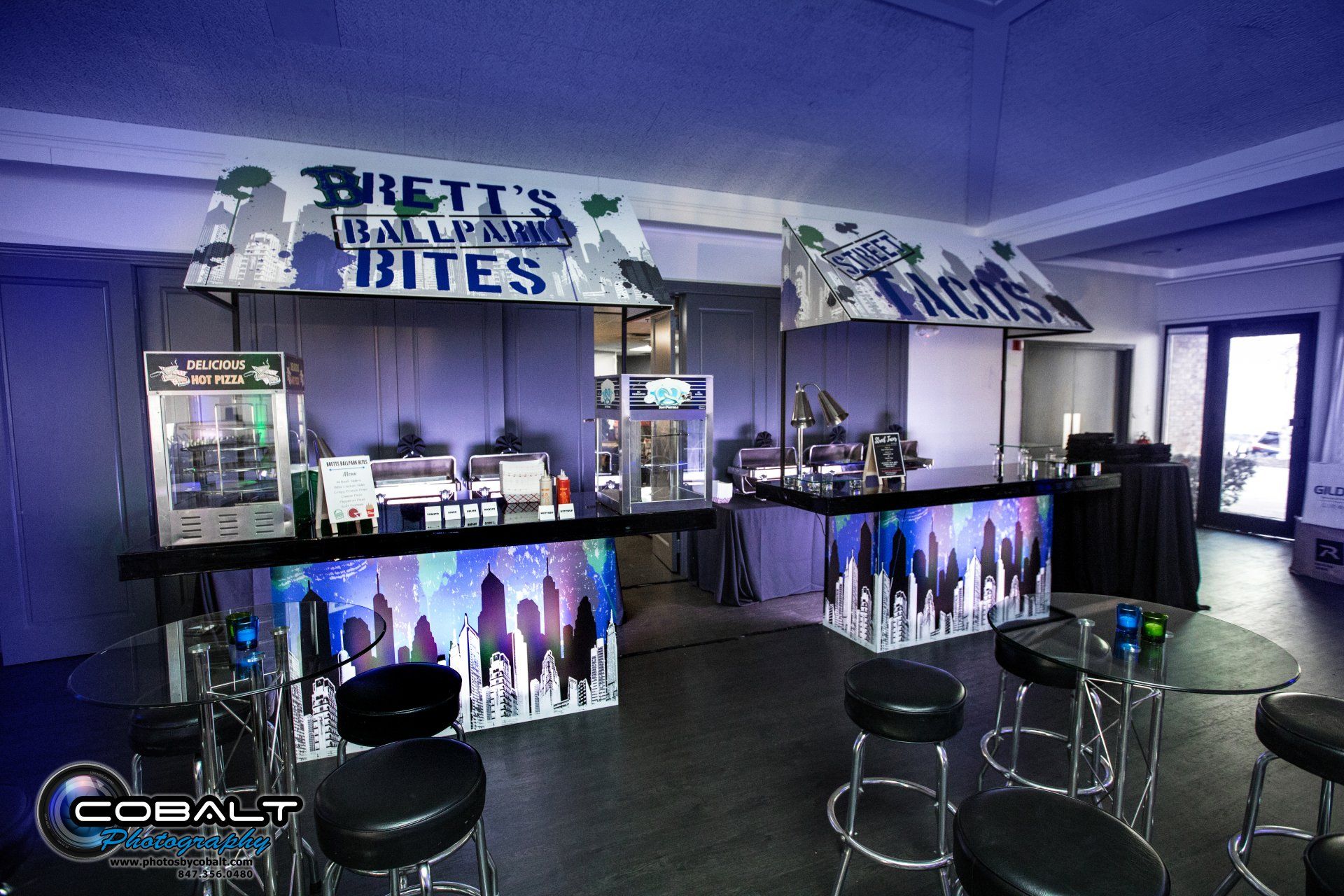 A large room with a bar and stools and a sign that says brett 's halloween bites.