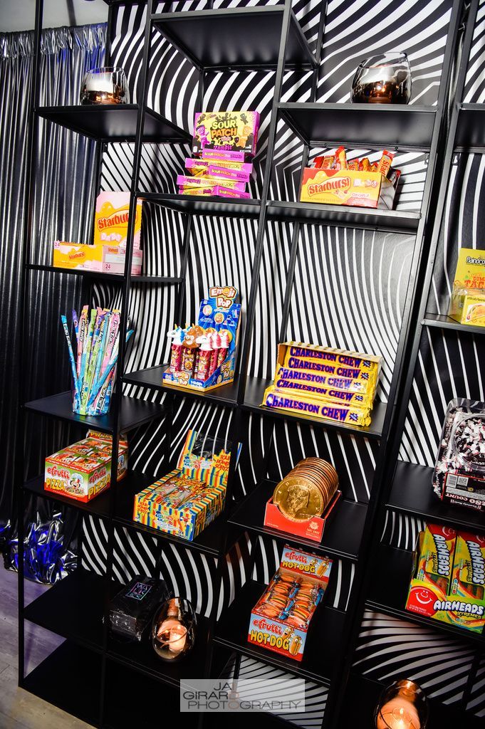 There are many different types of candy on the shelves.