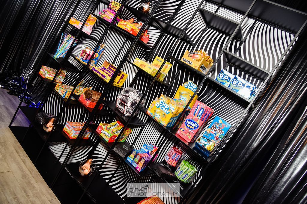 There are many different types of candy on the shelves.