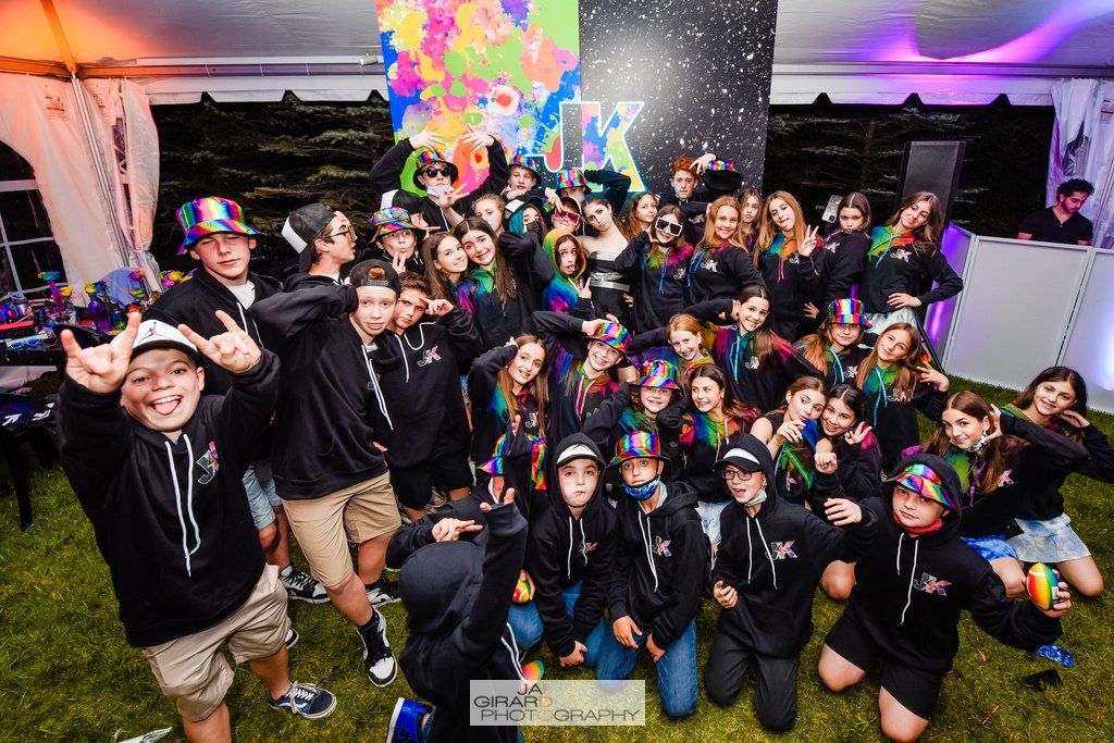 A group of children are posing for a picture in front of a tent.