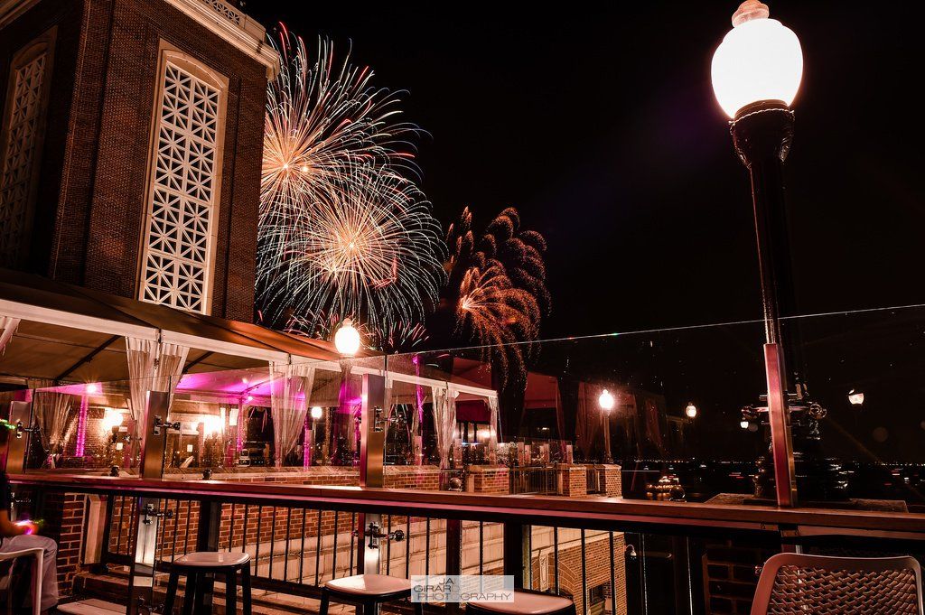 There is a fireworks display in the background of a restaurant.