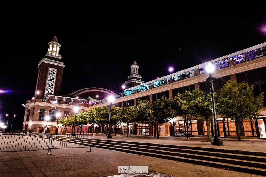 A large building with a clock tower is lit up at night.