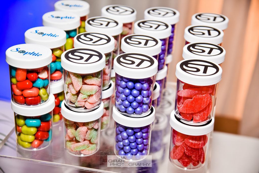 A bunch of jars filled with different types of candy on a table.
