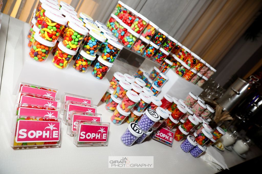 A table filled with jars of candy including m & m 's