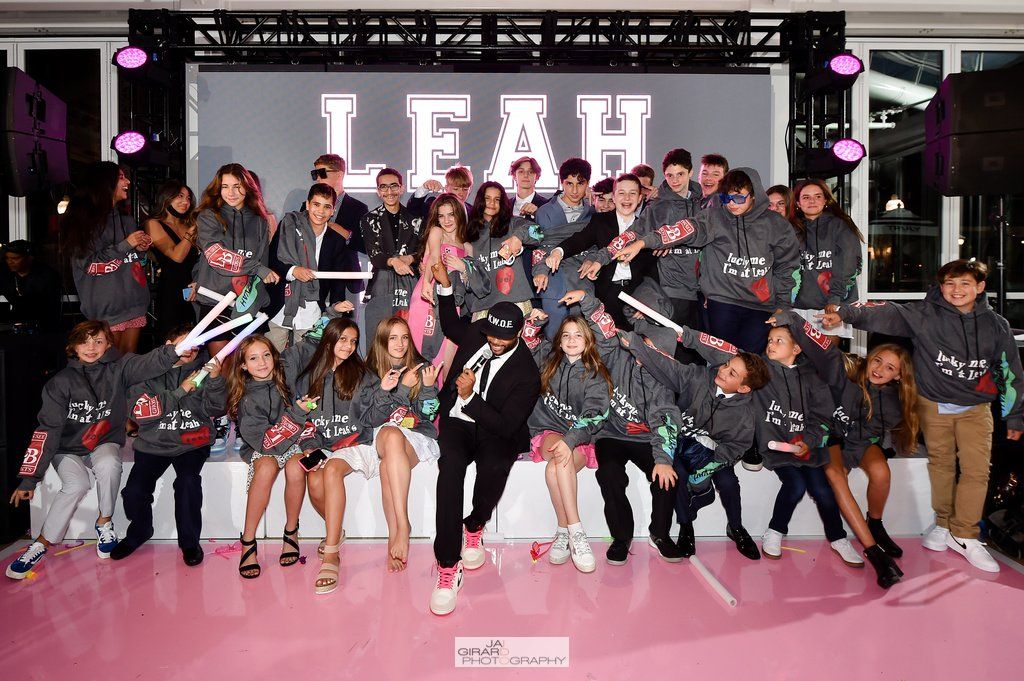 A group of people are posing for a picture in front of a large screen.