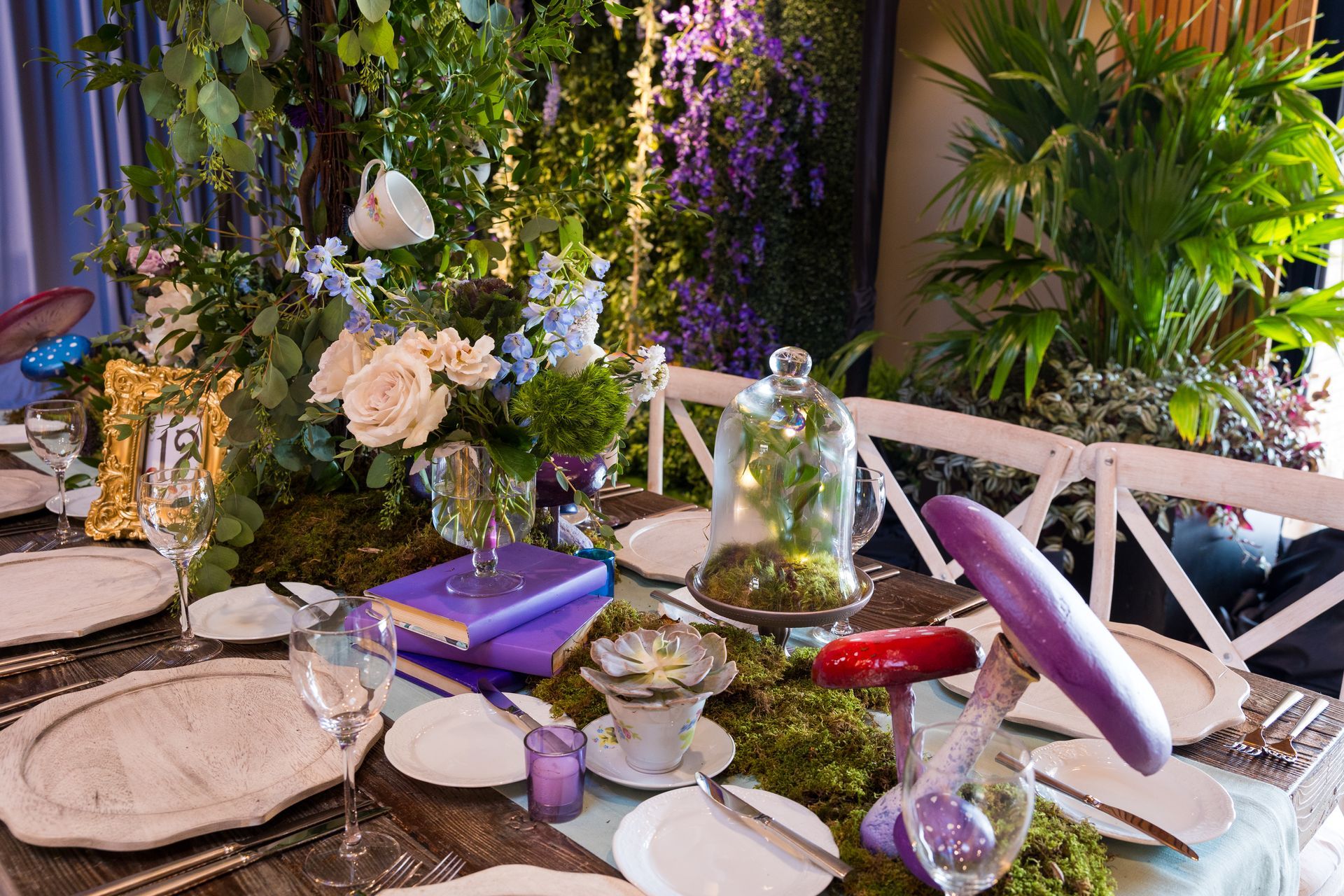 A table with plates , utensils , flowers and mushrooms on it.