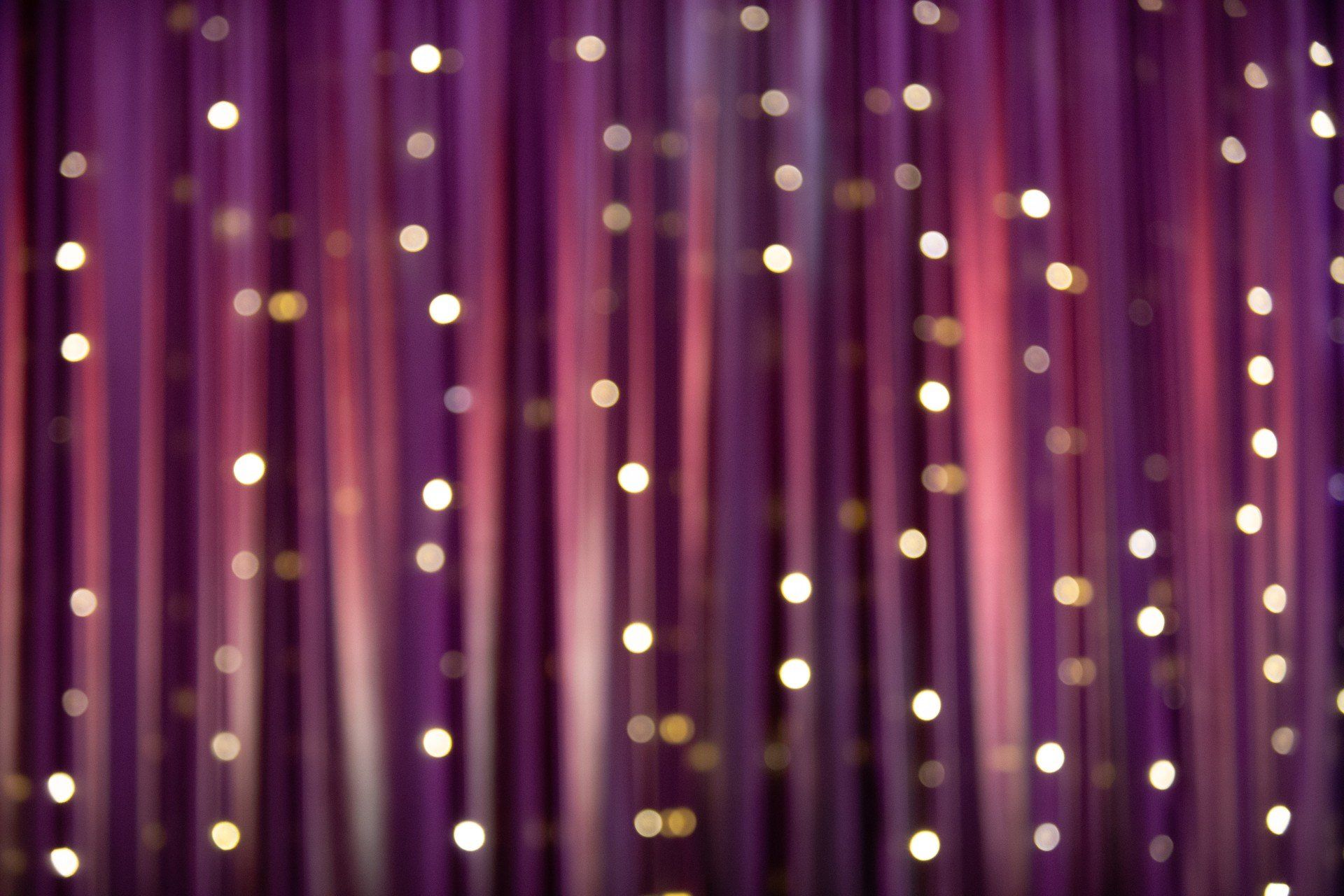 A purple curtain with christmas lights hanging from it.