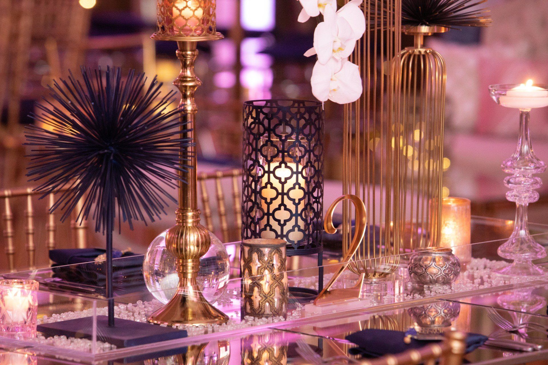 A table with a lot of candles and flowers on it.