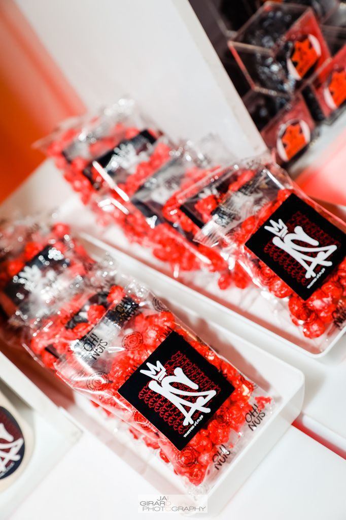 Three bags of red popcorn are sitting on a table.