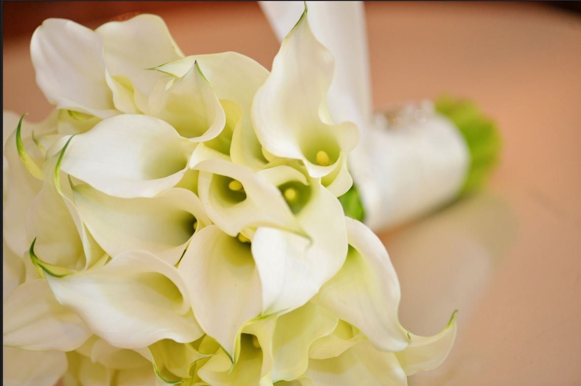 A close up of a bouquet of white flowers on a table.