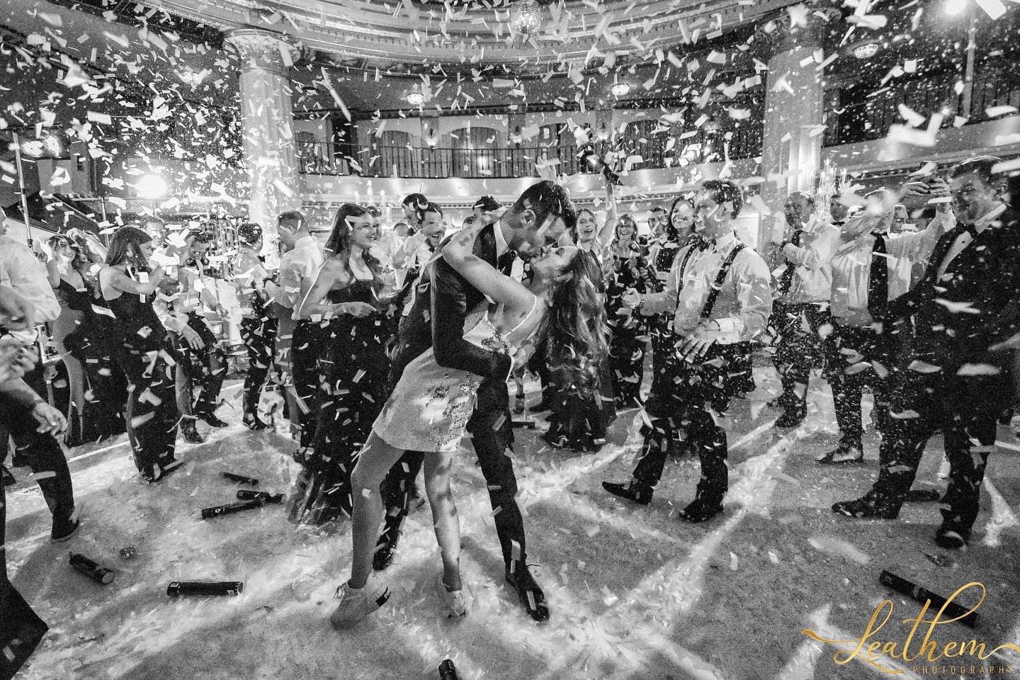 A black and white photo of a bride and groom dancing at a wedding reception.
