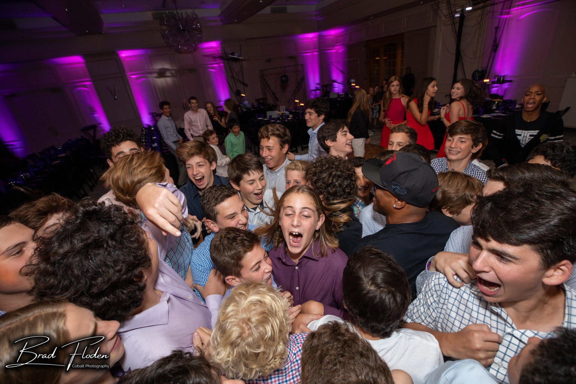 A large group of people are dancing in a room at a party.