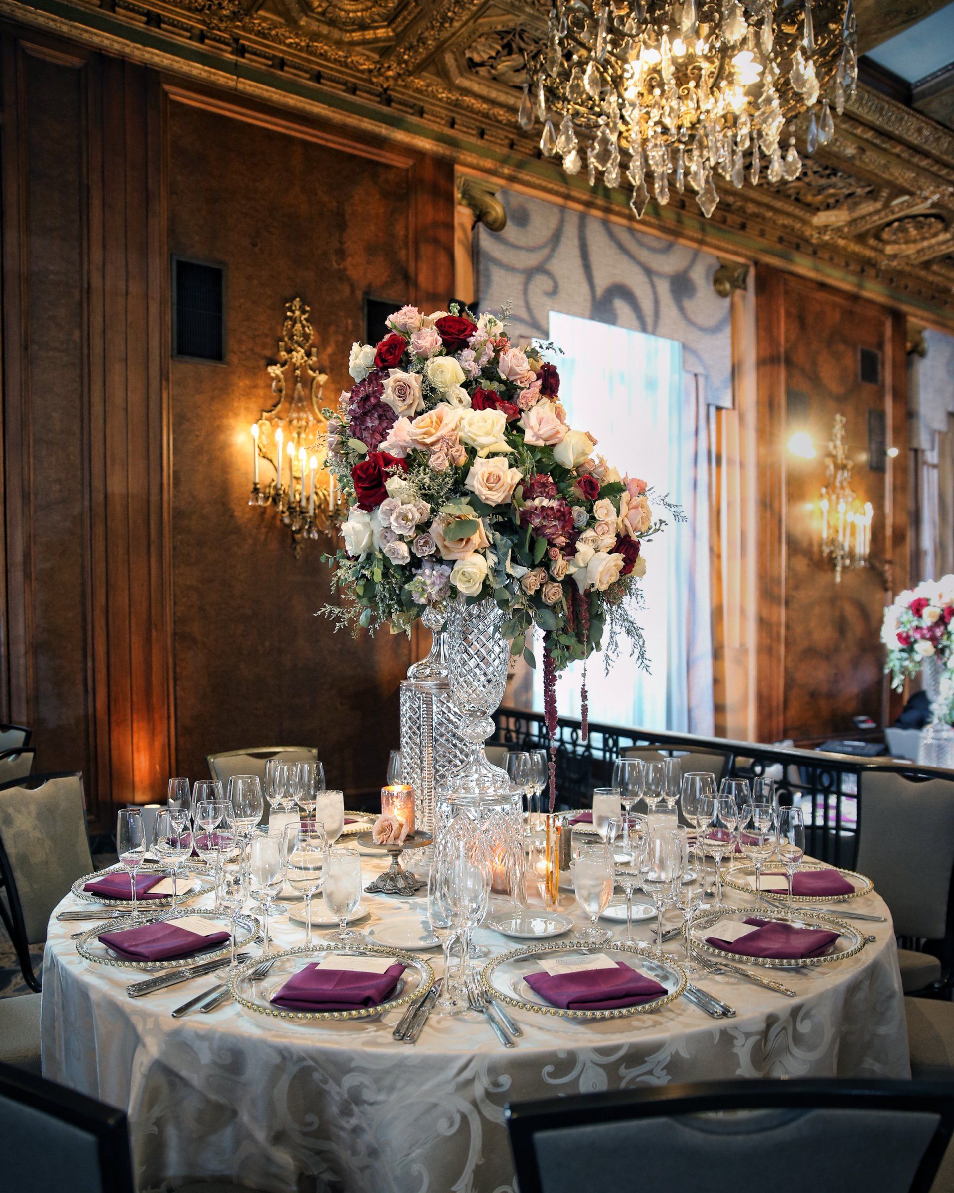 A large vase filled with flowers sits on a table