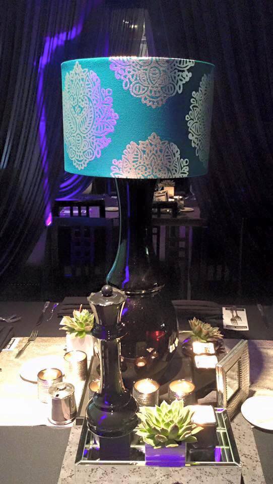 A lamp with a blue shade is sitting on top of a table.