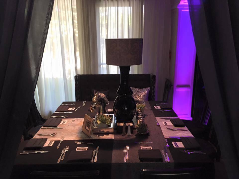 A dining room table with purple lights behind it