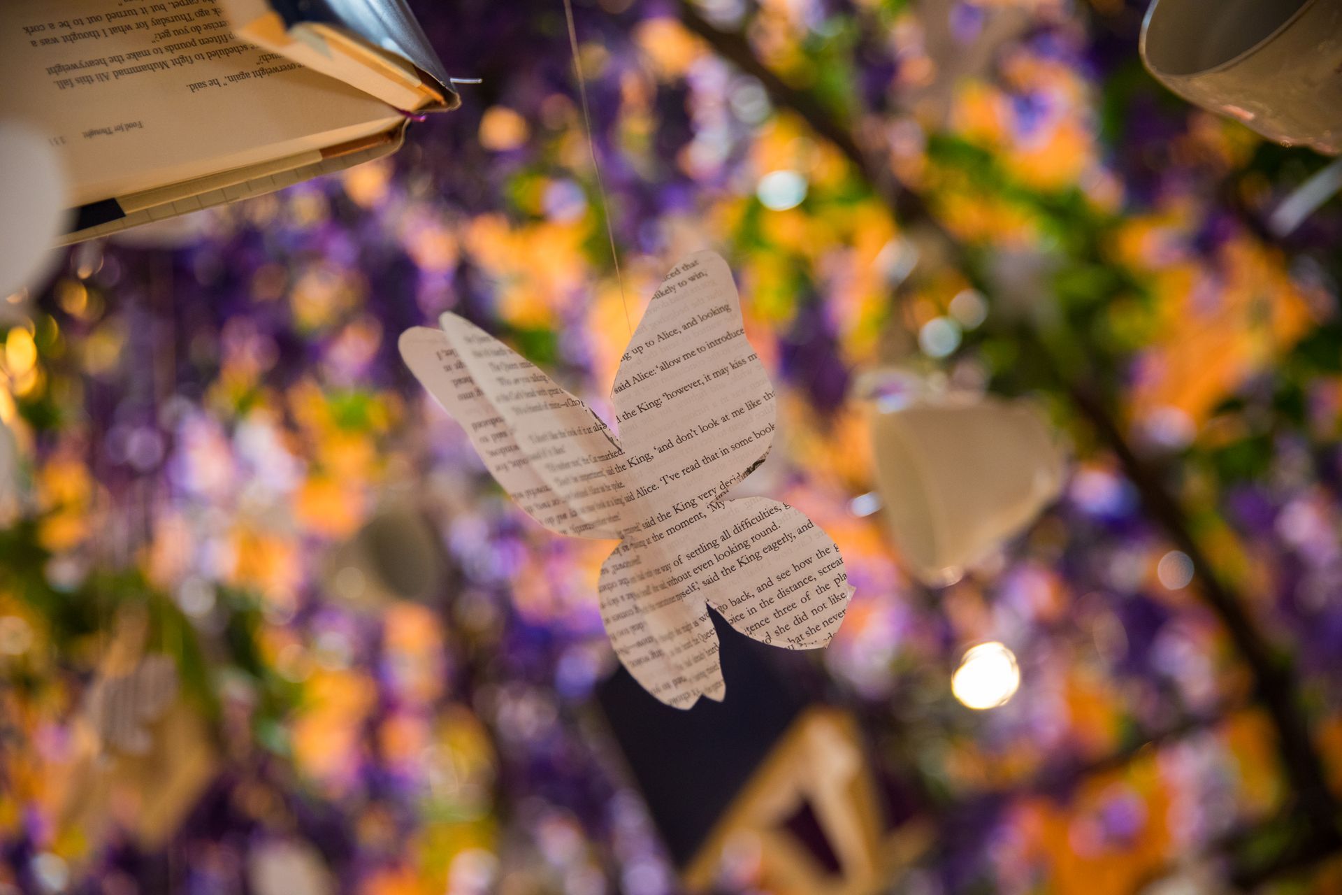 A butterfly made out of book pages is hanging from the ceiling.