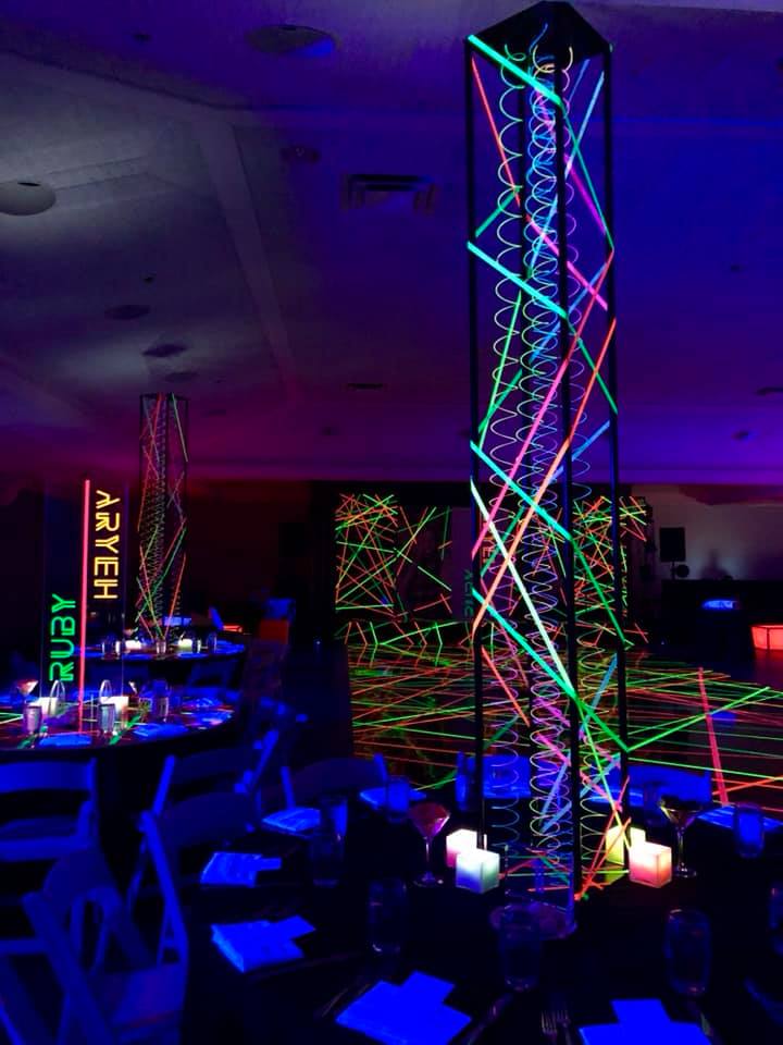A room with tables and chairs decorated with glow in the dark lights.