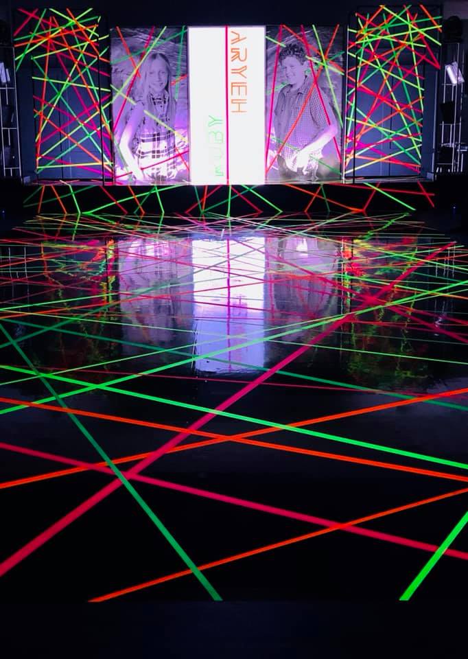 A stage with glow in the dark lights and a sign that says aryeh